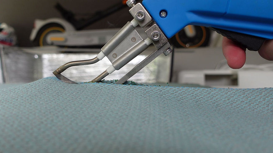 A blue-handled Sailrite hot knife cuts blue fabric.